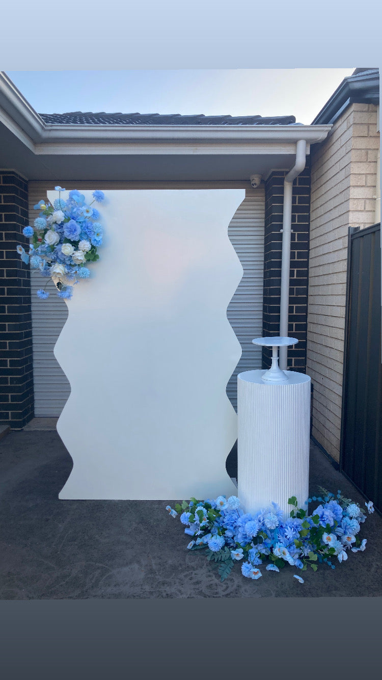 Package Hire includes 1 wooden backdrop 2m H x 1.2m W +1 ripple plinth + 2 flowers